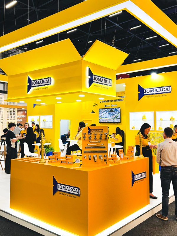 Estande da Jomarca Kits na Formóbile 2026, com balcão de produtos e painel de ferragens.